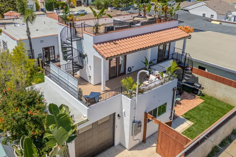 West LA ADU side aerial view showing attached garage, rooftop deck, and spiral staircase access to upper rooftop perch
