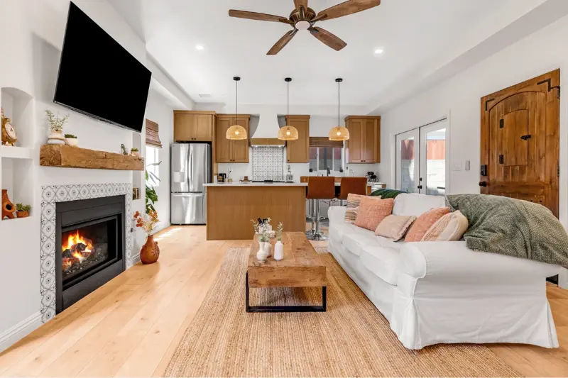 West LA ADU living room with vaulted ceiling, tile-clad fireplace, mounted TV, and open sight line to kitchen and dining