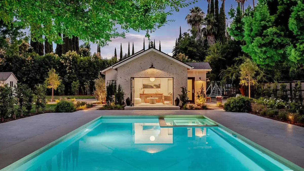Custom CALI ADU pool house in Woodland Hills at dusk — a one-of-one design opening onto the pool