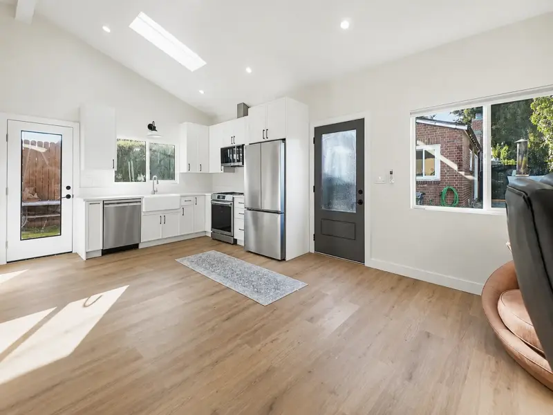 Full-size kitchen in the Mar Vista garage conversion ADU with white shaker cabinets, quartz counters, farmhouse sink, and stainless appliances under a skylight