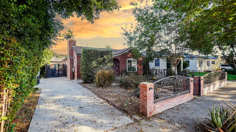 Red-brick main house in Mar Vista at dusk — the ADU stucco color was custom-mixed to coordinate with this brick