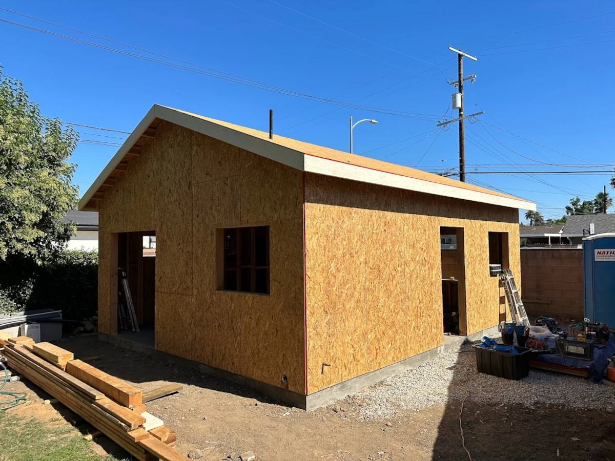 Detached ADU under construction in a Los Angeles backyard with gable roof framing and sheathing by CALI ADU design-build team