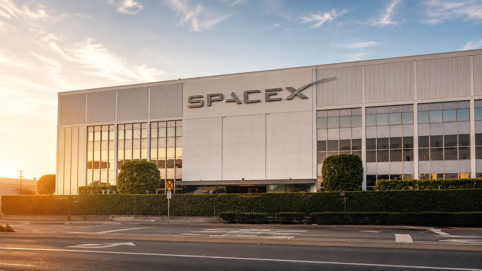 Building an ADU in Hawthorne, CA — the SpaceX headquarters on the South Bay aerospace corridor at golden hour, an employment hub driving rental demand where CALI ADU permits backyard ADUs under HMC § 17.21 and California state law